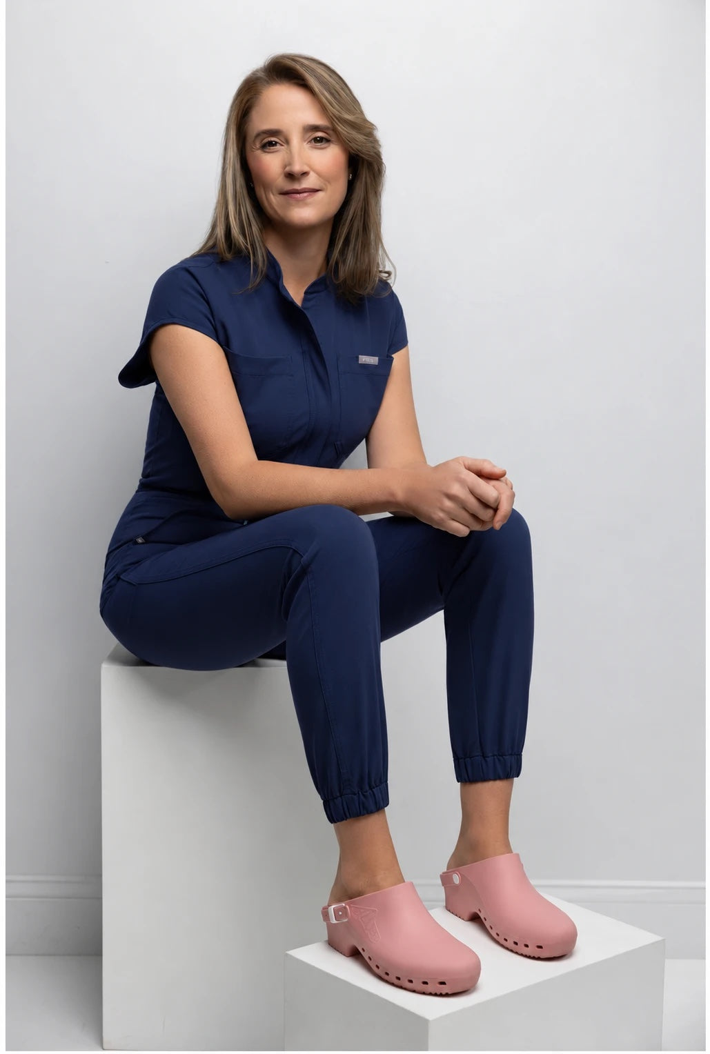 Dr. Alexis Parcells, board-certified plastic surgeon and founder of SUNNIE, in navy scrubs